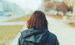 Rear view of woman on city street in cold winter afternoon